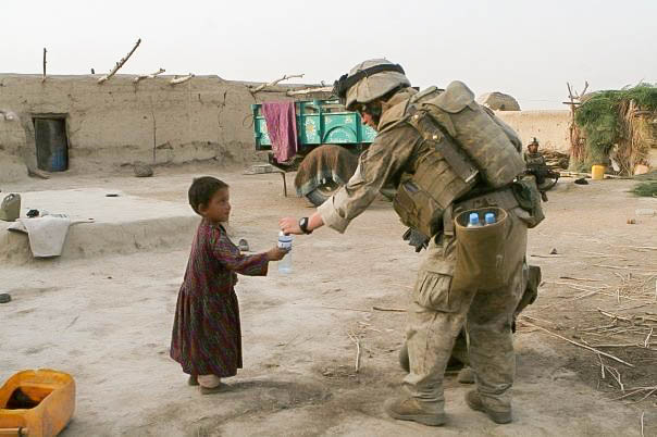 Zachary Bell giving water to a little girl in Afghanistan