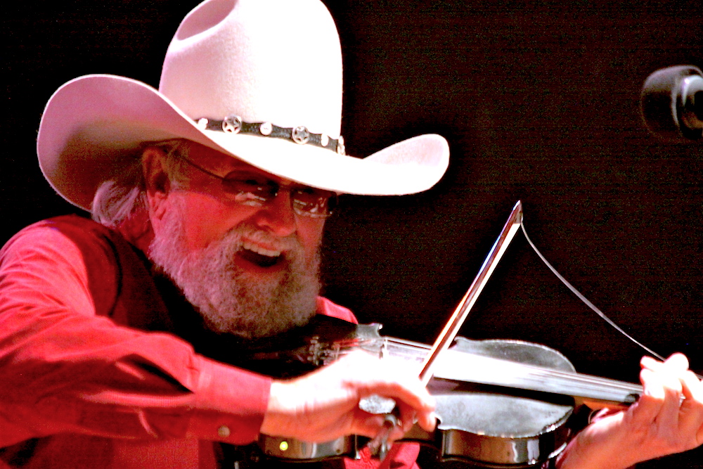 Charlie Daniels plays fiddle on stage.