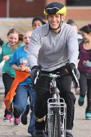Paul departs from Legacy on his bike with children in tow.