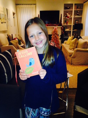Kari Kampakis' daughter with a copy of Jesus Calling 365 Devotions for Kids.