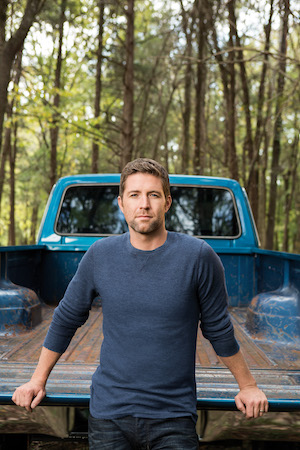Josh Turner standing by his blue truck.