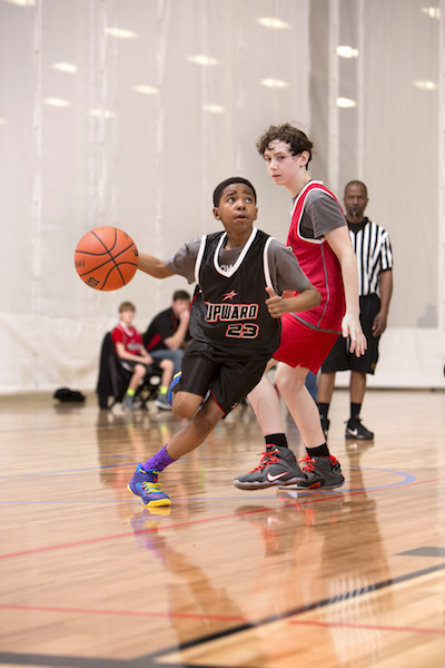A boy with the Upward program dribbles a basketball.