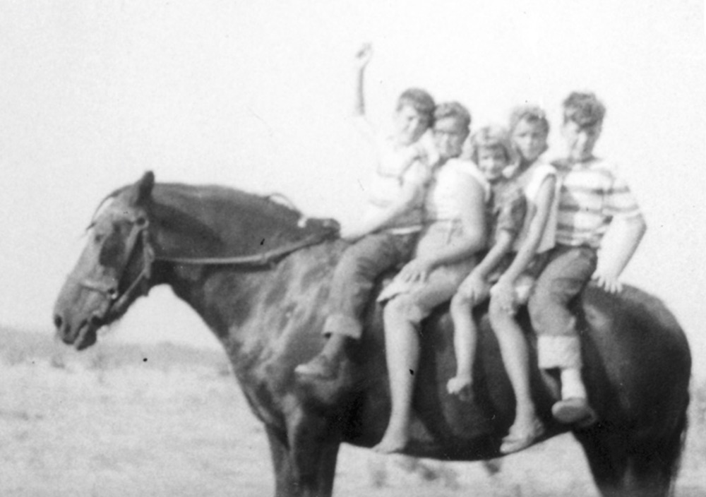 Edie Sundby as a child on a horse with her siblings.