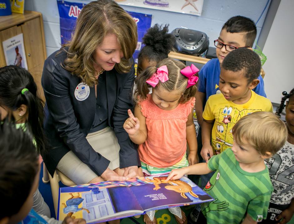 First Lady Crissy Haslam reading a book to children.