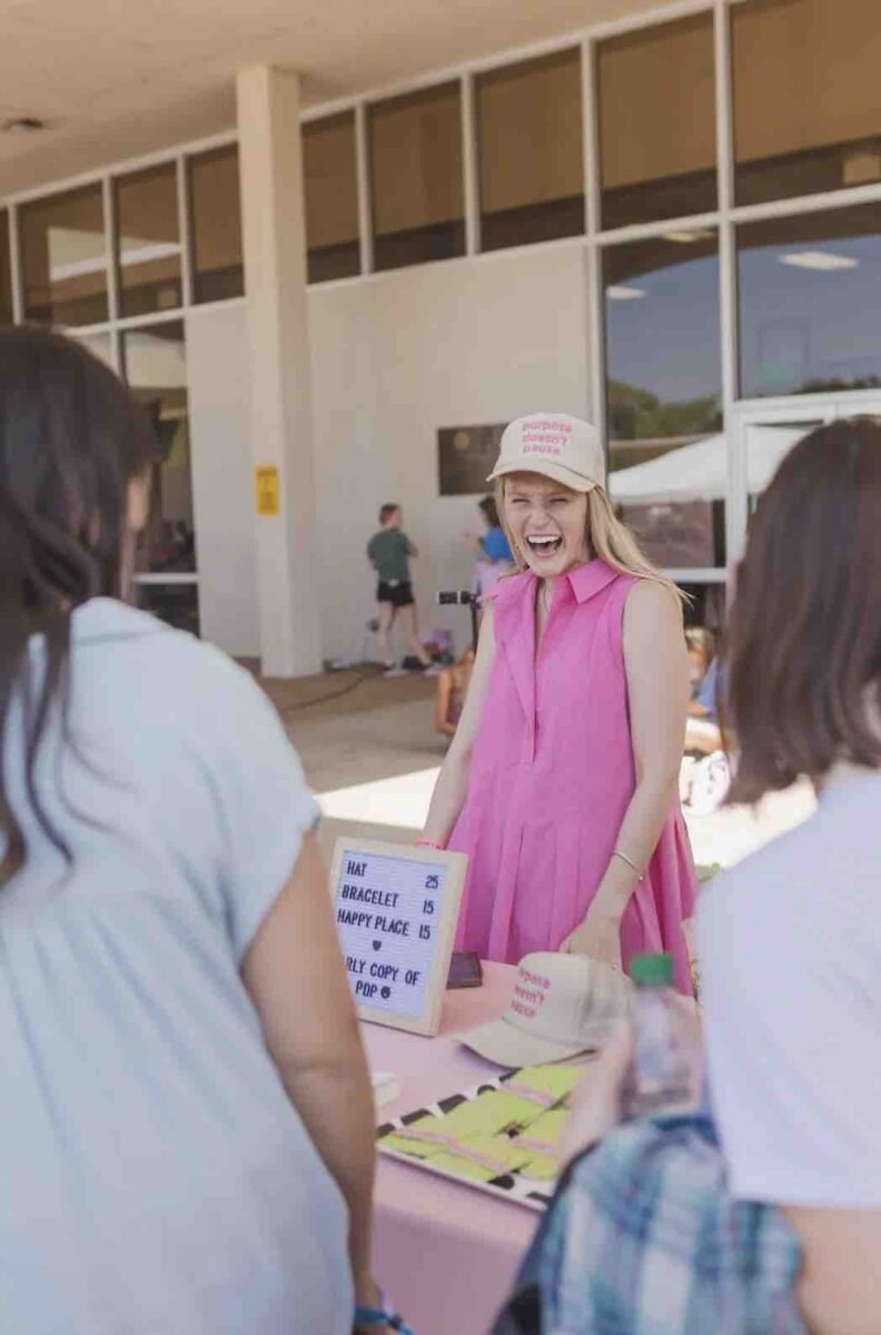 Jesus Calling podcast 458 featuring Hope Reagan Harris - Purpose Doesn't Pause - shown here smiling at a group from her merch table