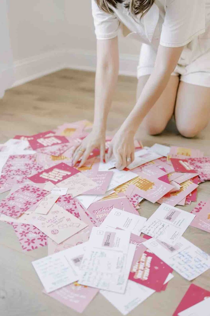 Jesus Calling podcast 458 featuring Hope Reagan Harris - Purpose Doesn't Pause - shown here on her knees looking through postcards